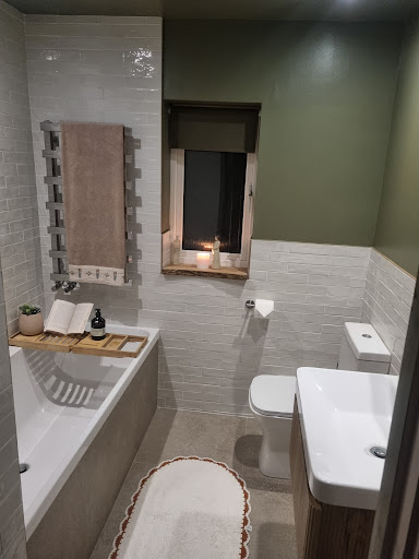 Olive green bathroom with freestanding bath and metro tile splashback by Misbourne Plumbing
